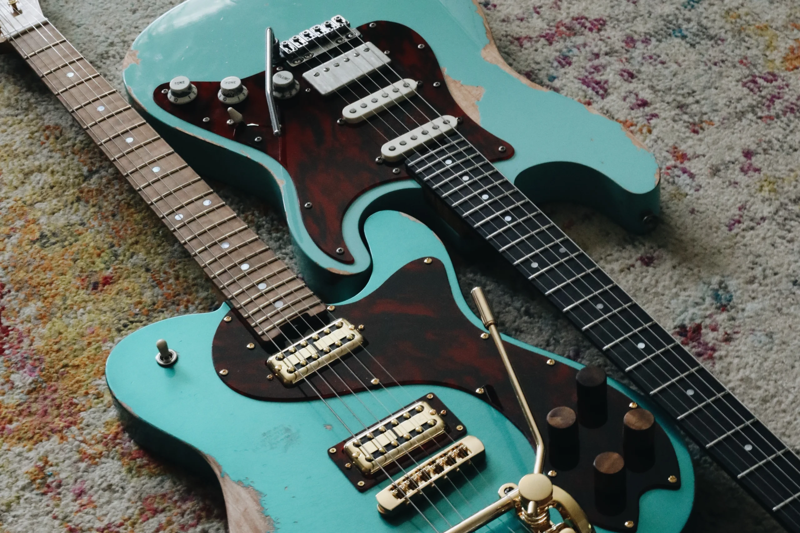 Two seafoam green Luxe guitars, relic finish